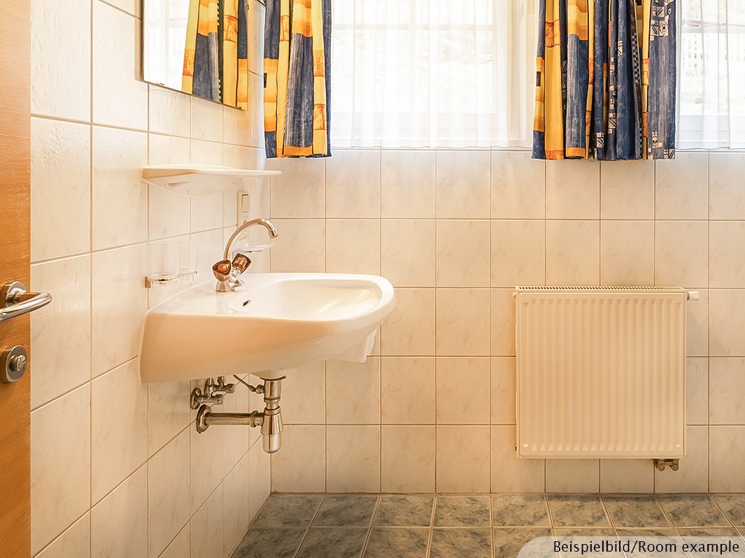 Das Bild zeigt Waschbecken mit Spiegel und Heizung