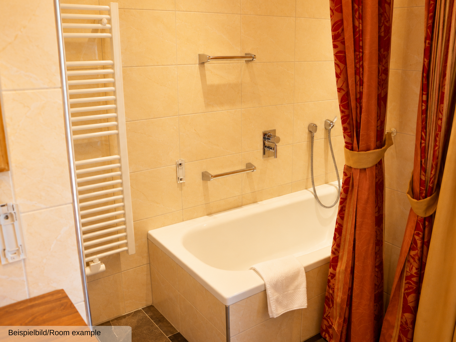 Beispielfoto eines offenen Badezimmers in der Juniorsuite mit Badewanne, durch einen Vorhang vom Wohnbereich getrennt